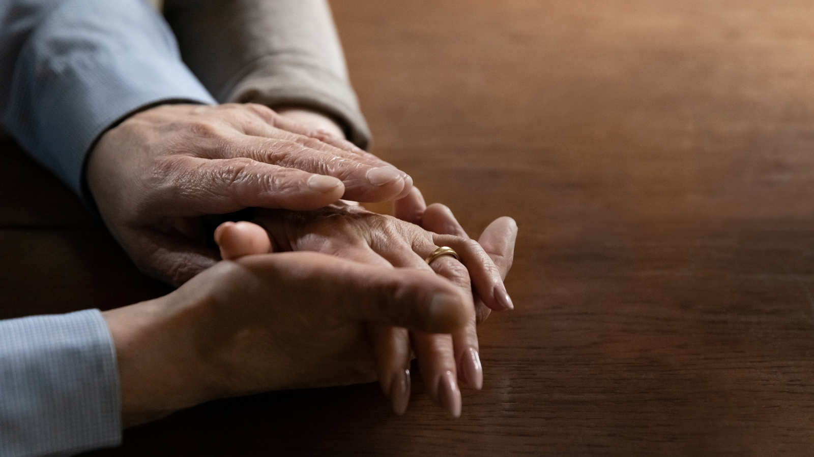 Senior mature man holding hand of partner illustrating empathy and compassion