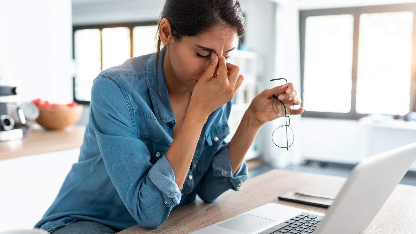 Stressed business woman working from home on laptop looking worried, tired and overwhelmed