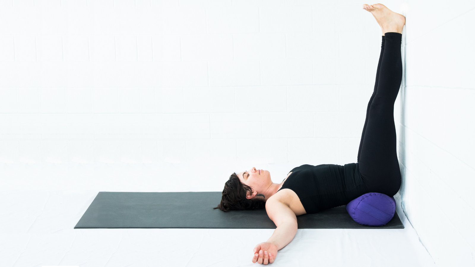 Yoga student practicing Legs up the Wall or Viparita Karani Pose