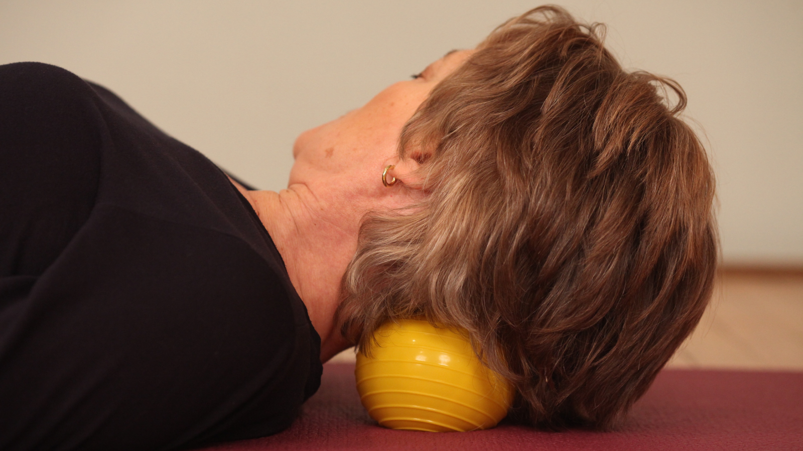 How to use a rubber exercise ball right under your neck to release pain and neck tension