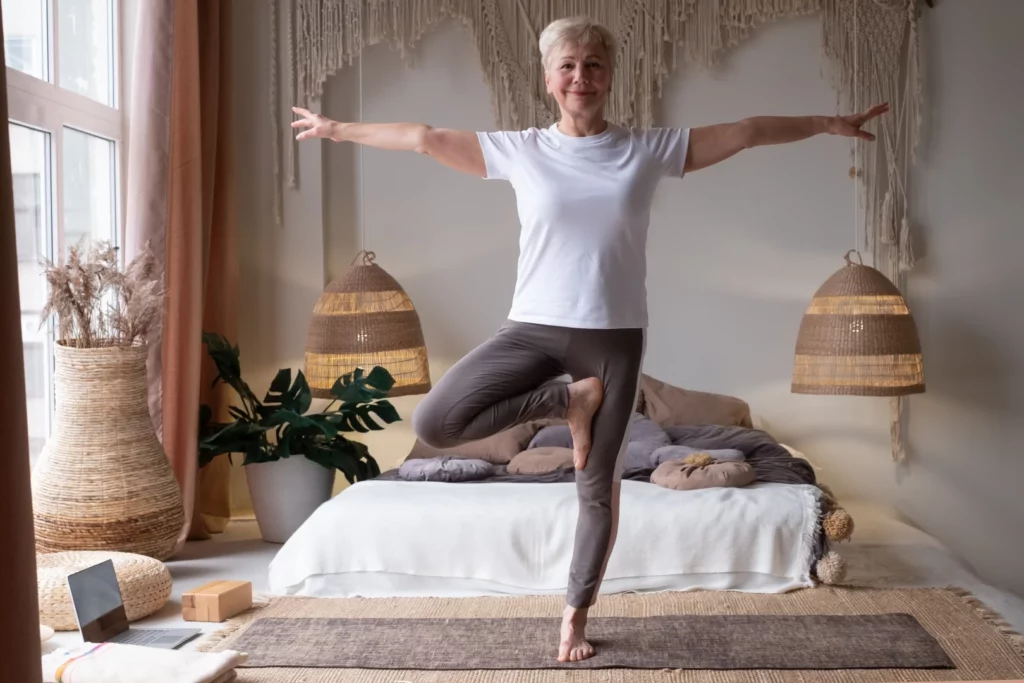 A person in a tree pose, a yoga pose for strong bones to prevent osteoporosis and improves balance.