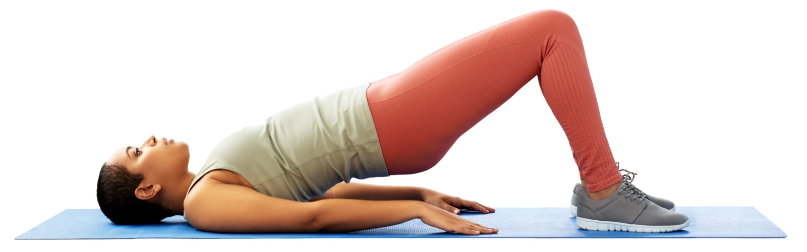 Beginner yoga student practicing Bridge Pose on a yoga mat (Sanskrit: Setu Bandha Sarvangasana)