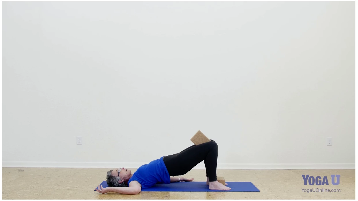 practicing Yoga's Bridge Pose with the use of the block to support good alignment and muscle engagement, and explore the glutes' role in backbends