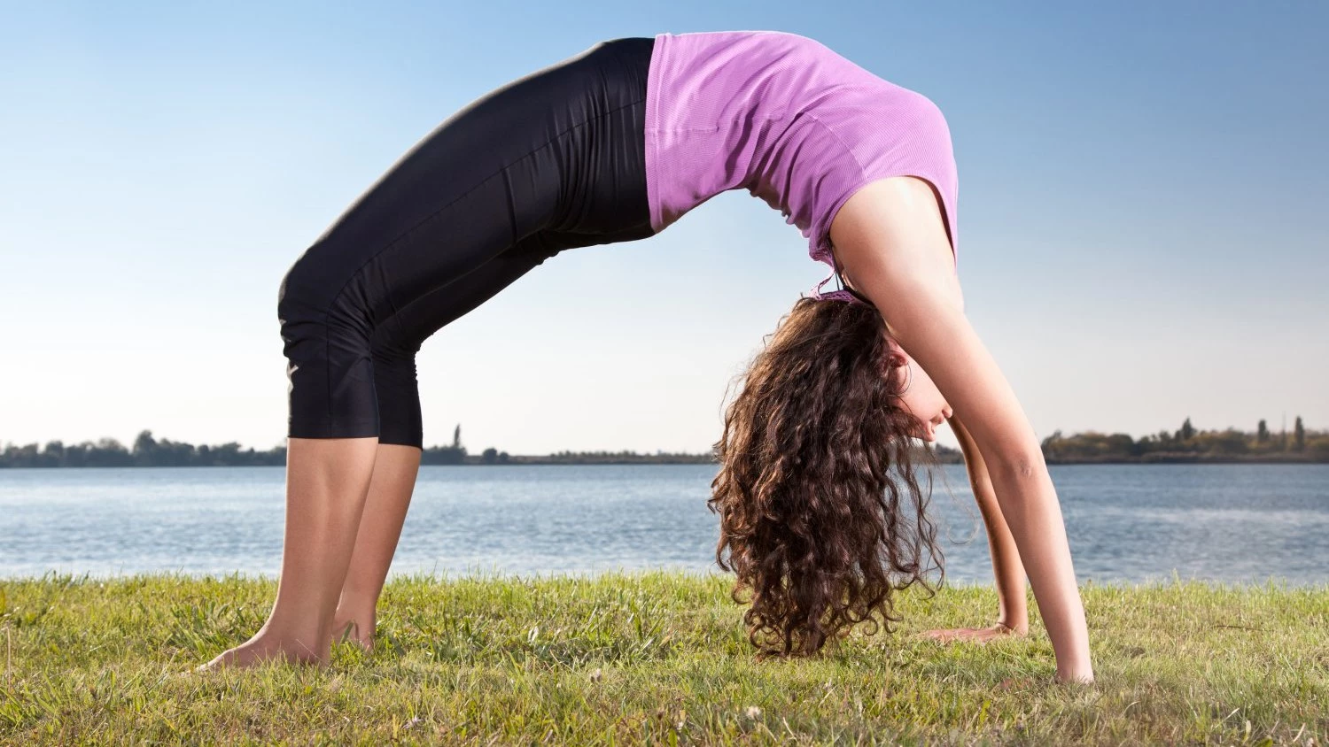 Woman doing yoga exercise full wheel pose on on mat in studio Stock Photo  by ©sorsillo 6259631