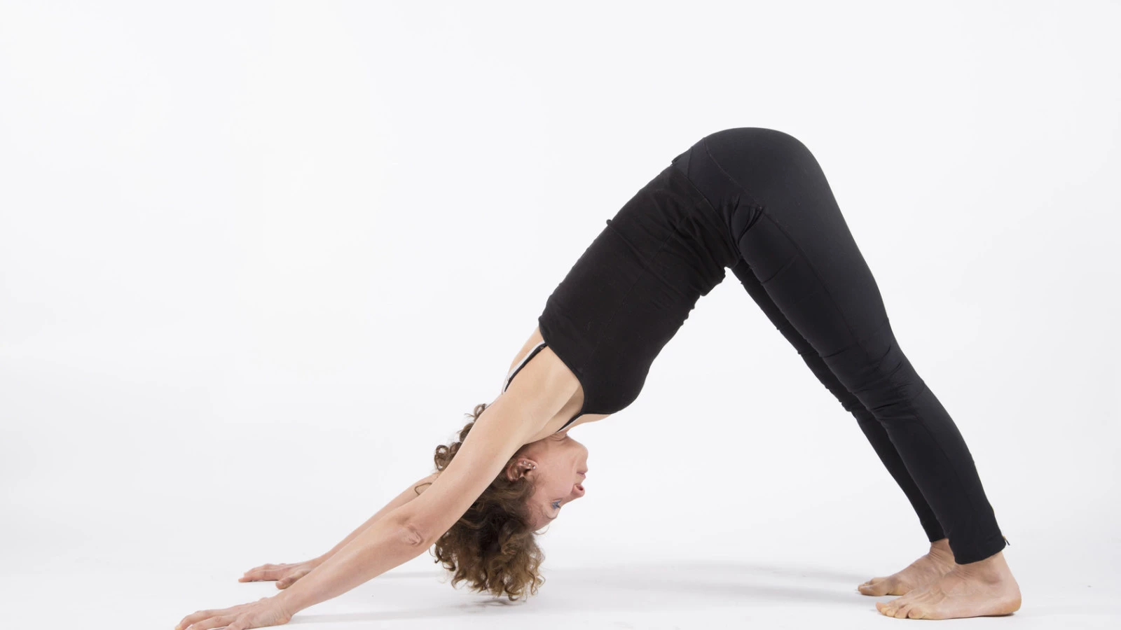 A woman in Downward Facing Dog Pose (Adho Mukha Svanasana), practicing healthy alignment in yoga