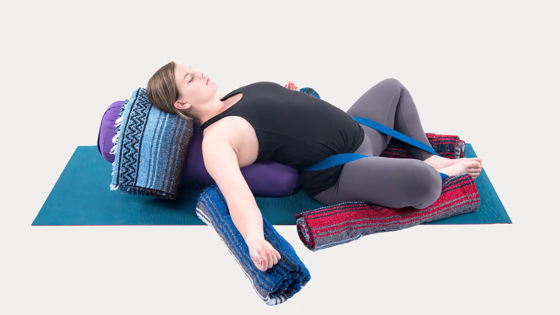 Woman practicing yoga supta baddha konasana.