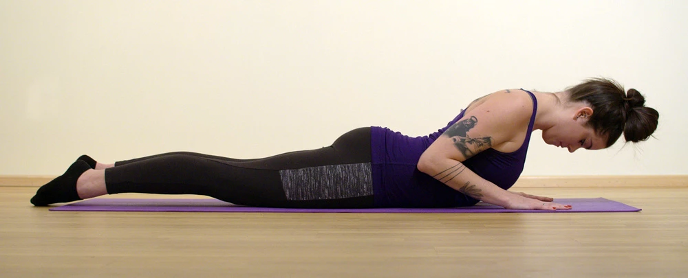 A yoga student practicing Cobra Pose (Bhujangasana) with her chin in an incorrect position 