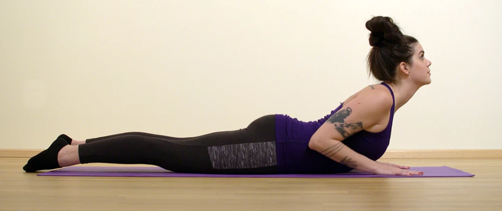 A yoga student practicing Cobra Pose (Bhujangasana) incorrectly, leading with her chin