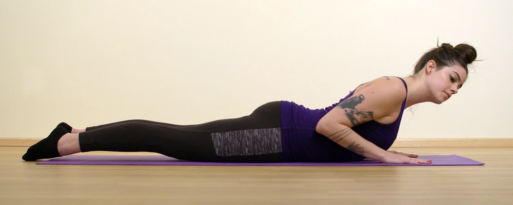 A yoga student in Cobra Pose (Bhujangasana) practicing with her head in an incorrect position (to the side)