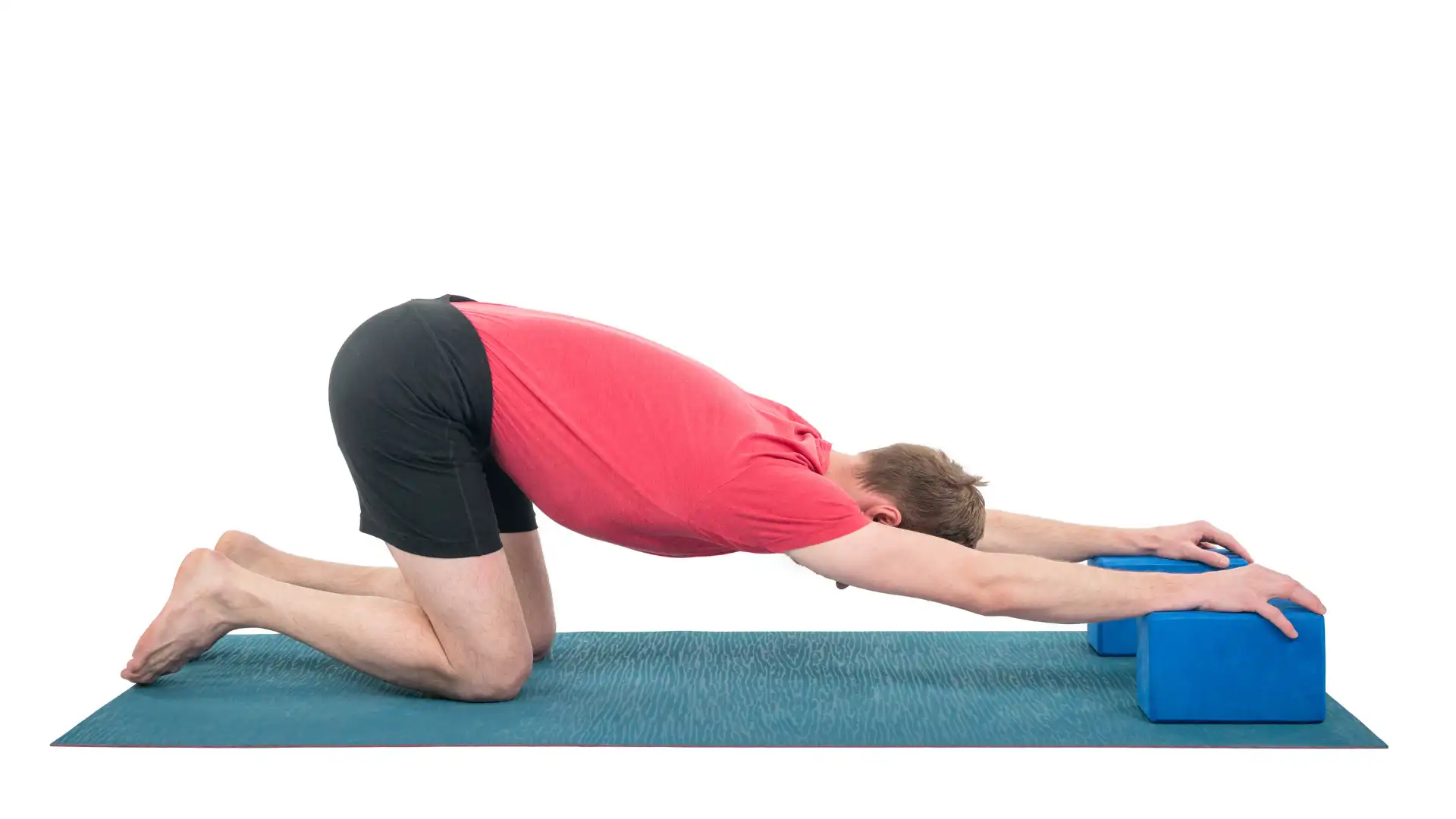 Man practicing puppy pose with his hands on yoga blocks.