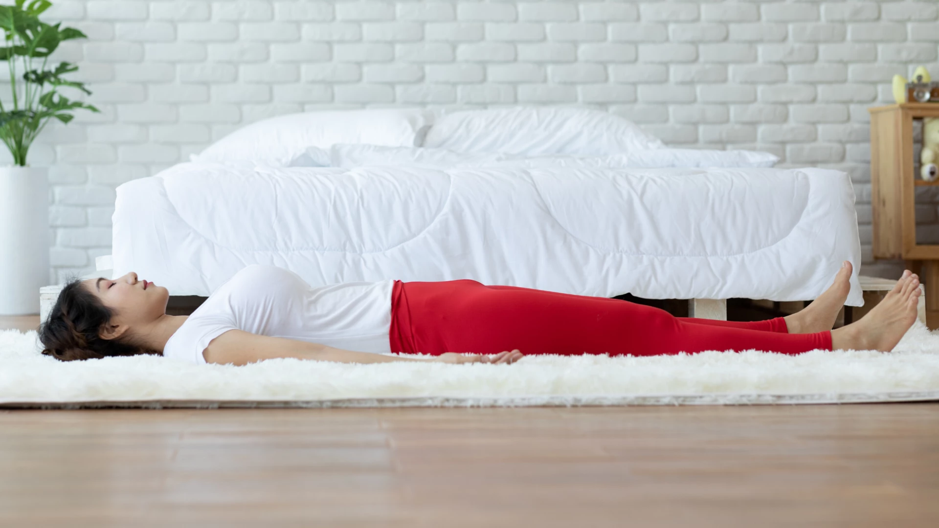 woman practicing savasana at home.