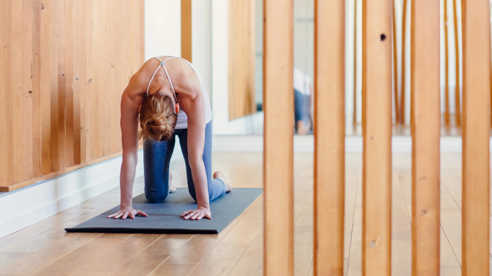 woman practicing cat-cow pose at home.