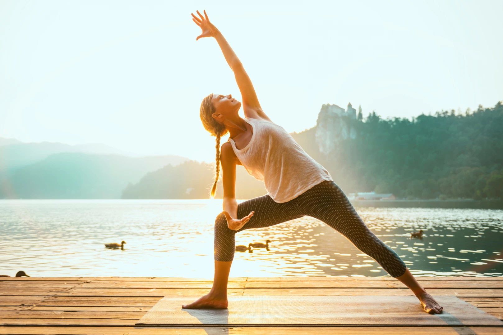 Woman practicing yoga outside, extended side angle pose, Utthita Parsvakonasana