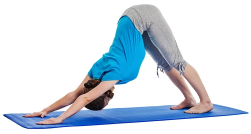 Woman in Downward-Facing Dog yoga pose (Adho Mukha Svanasana) in an axial extension posture for the spine