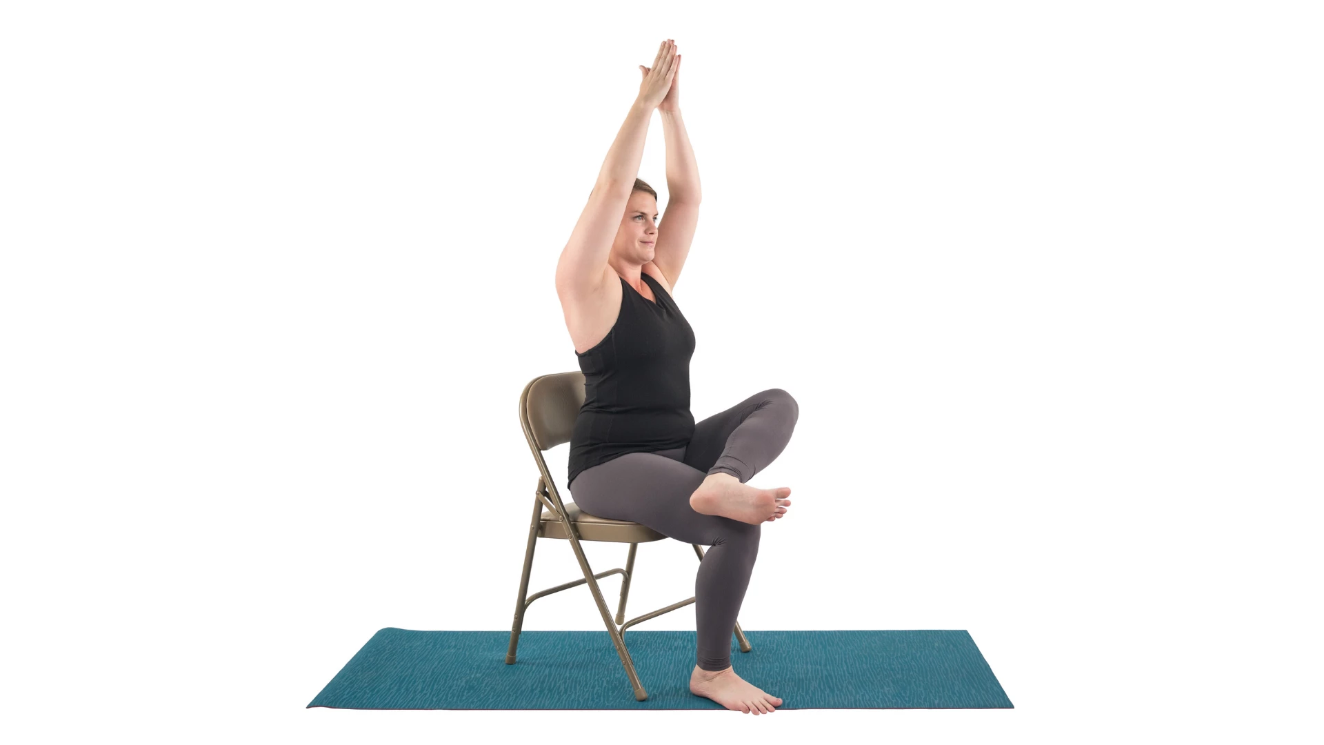 Woman practicing an accessible version of yoga tree pose sitting down in a chair.