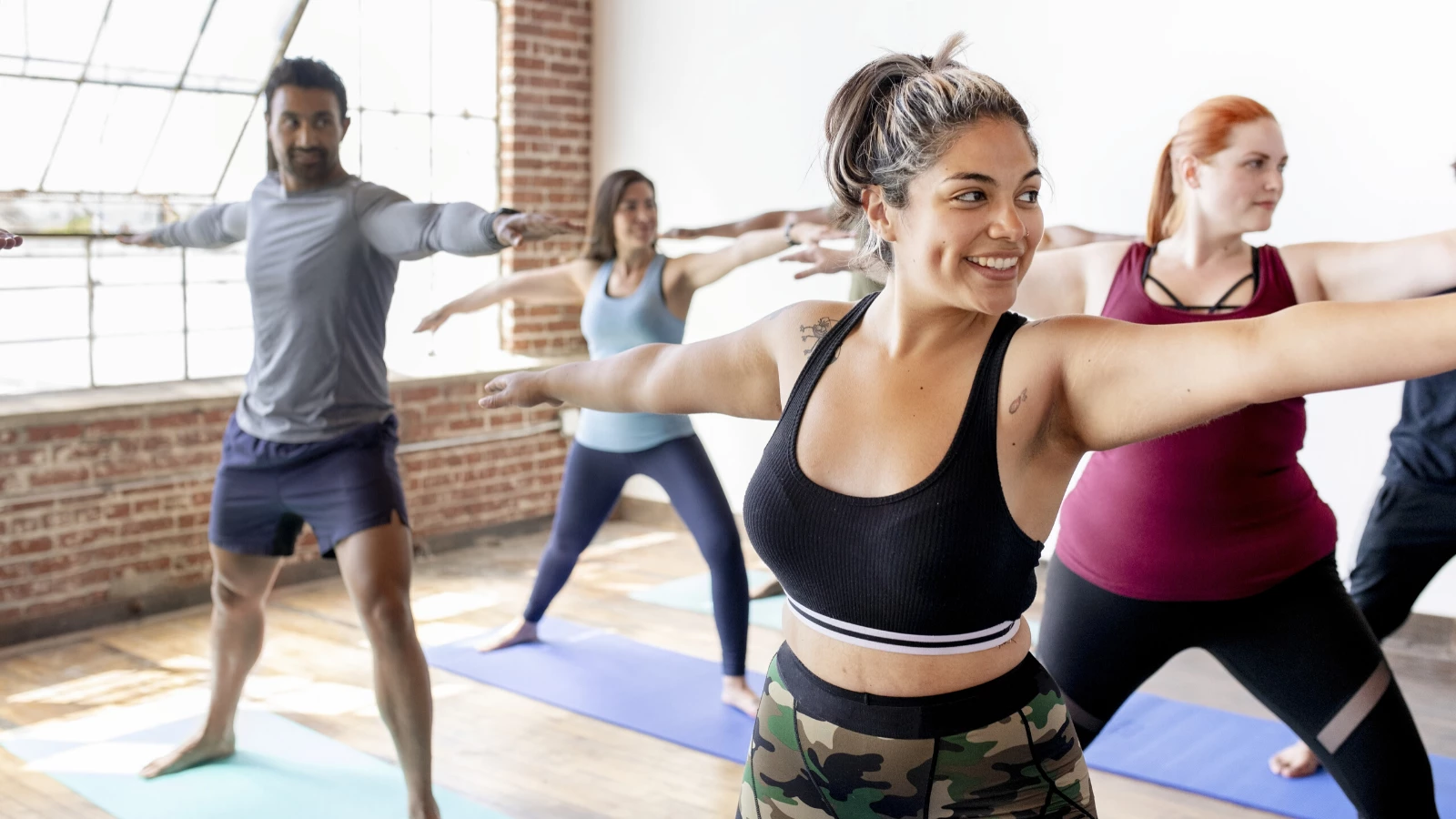 vinyasa yoga class practicing warrior II pose