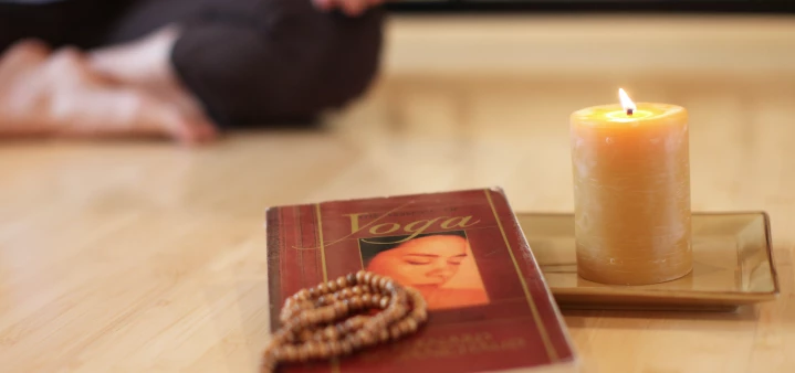 Yoga student in meditation reading yogic text