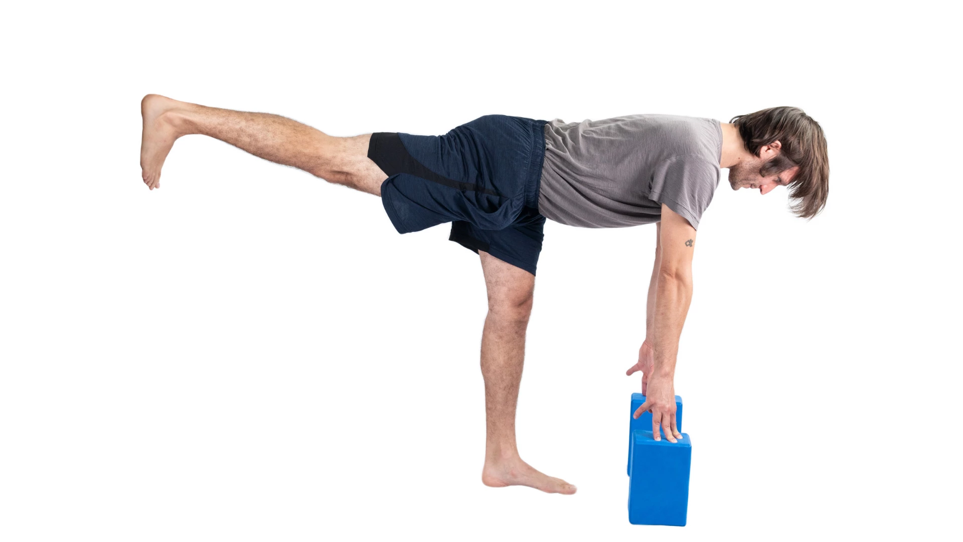 Man practicing warrior III with yoga blocks. 