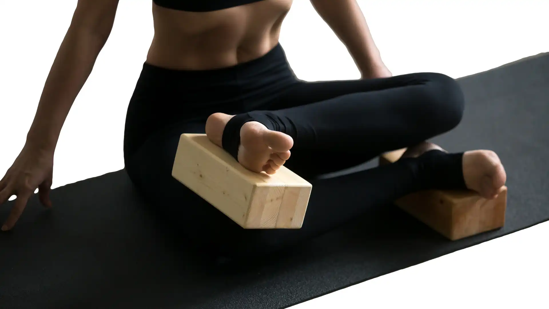 Close up of seated yoga pose using blocks for tight hips.