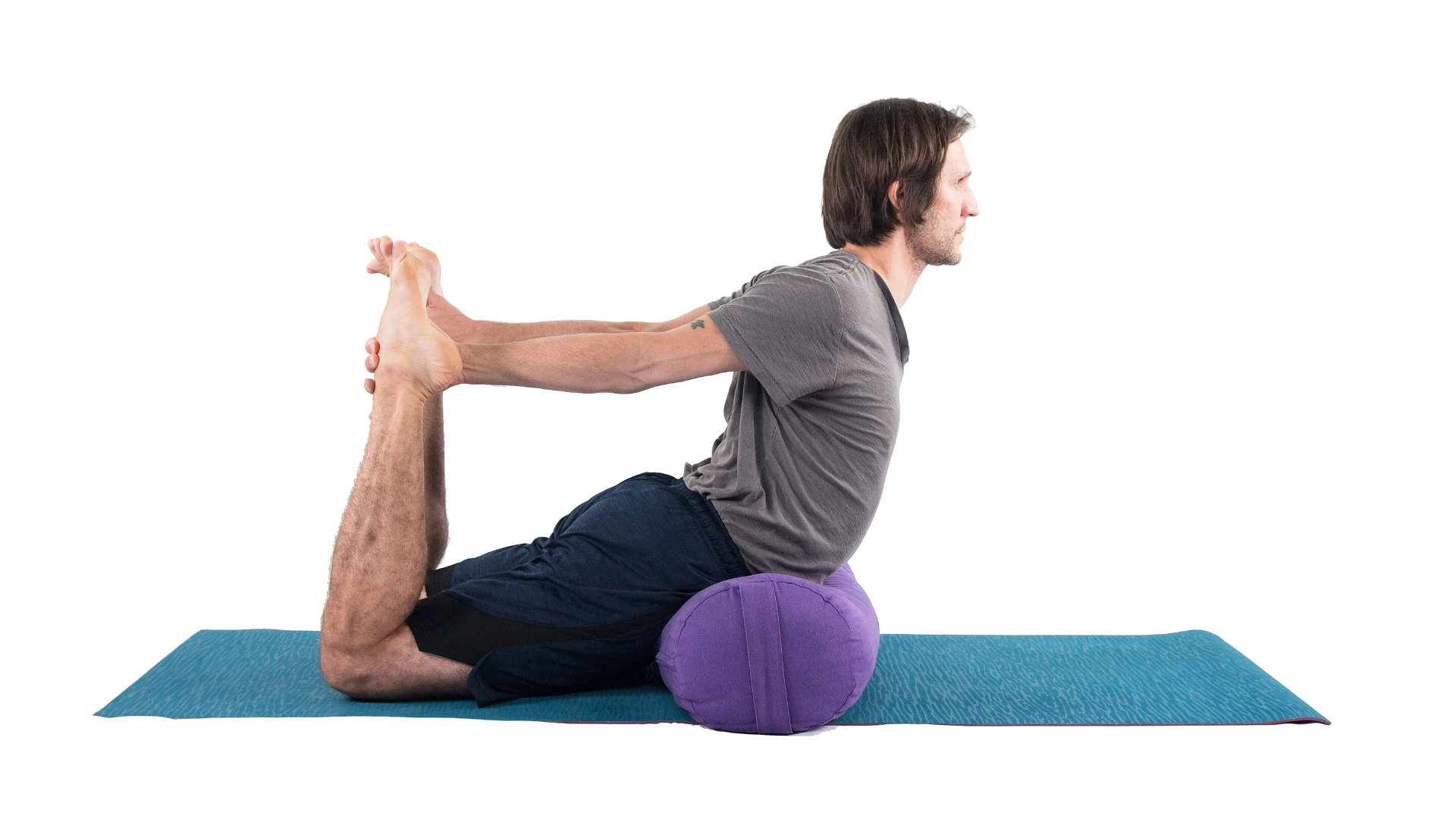 Man practicing dhanurasana bow pose with props.