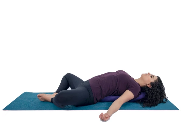 Woman practicing relaxing yoga pose - Supta Baddha Konasana