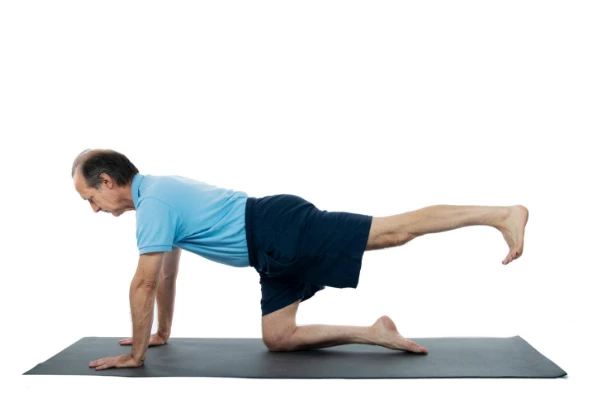 Man Practicing yoga hunting dog pose