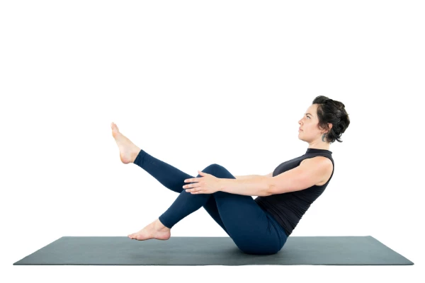 Woman practicing Yoga Core Strength Navasana Boat Pose