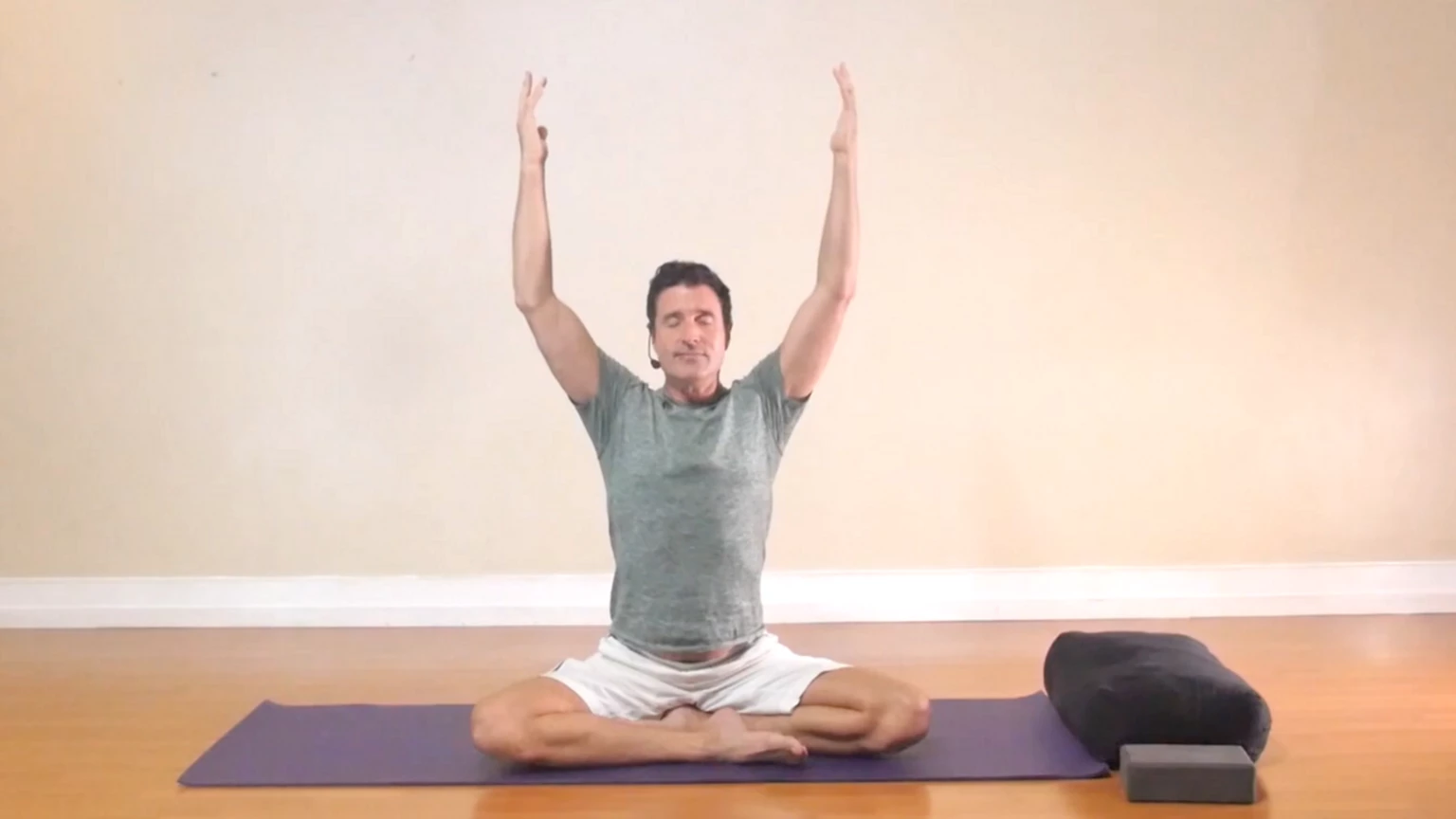 James Knight practicing Gentle Somatic Yoga seated pose arms raised