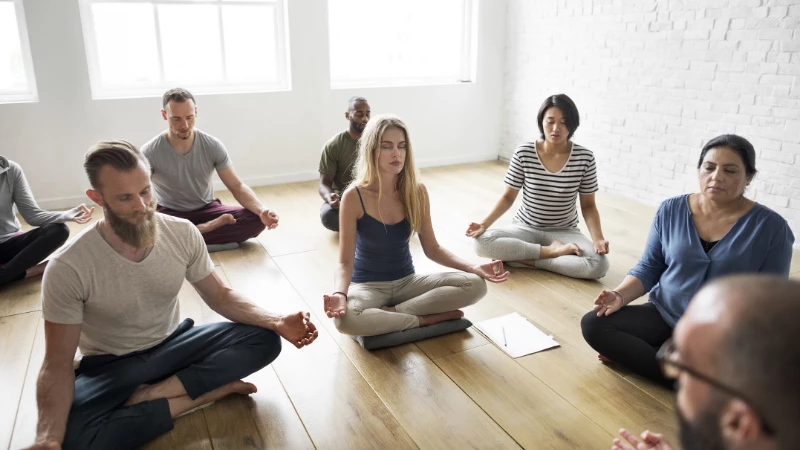 Yoga teacher guiding his students in a meditation. 