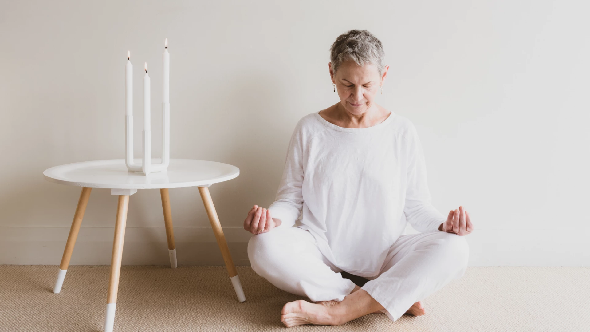 Woman practicing meditation with candles. 