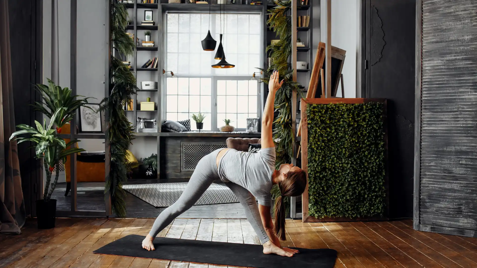 Woman practicing yoga revolved triangle at home.