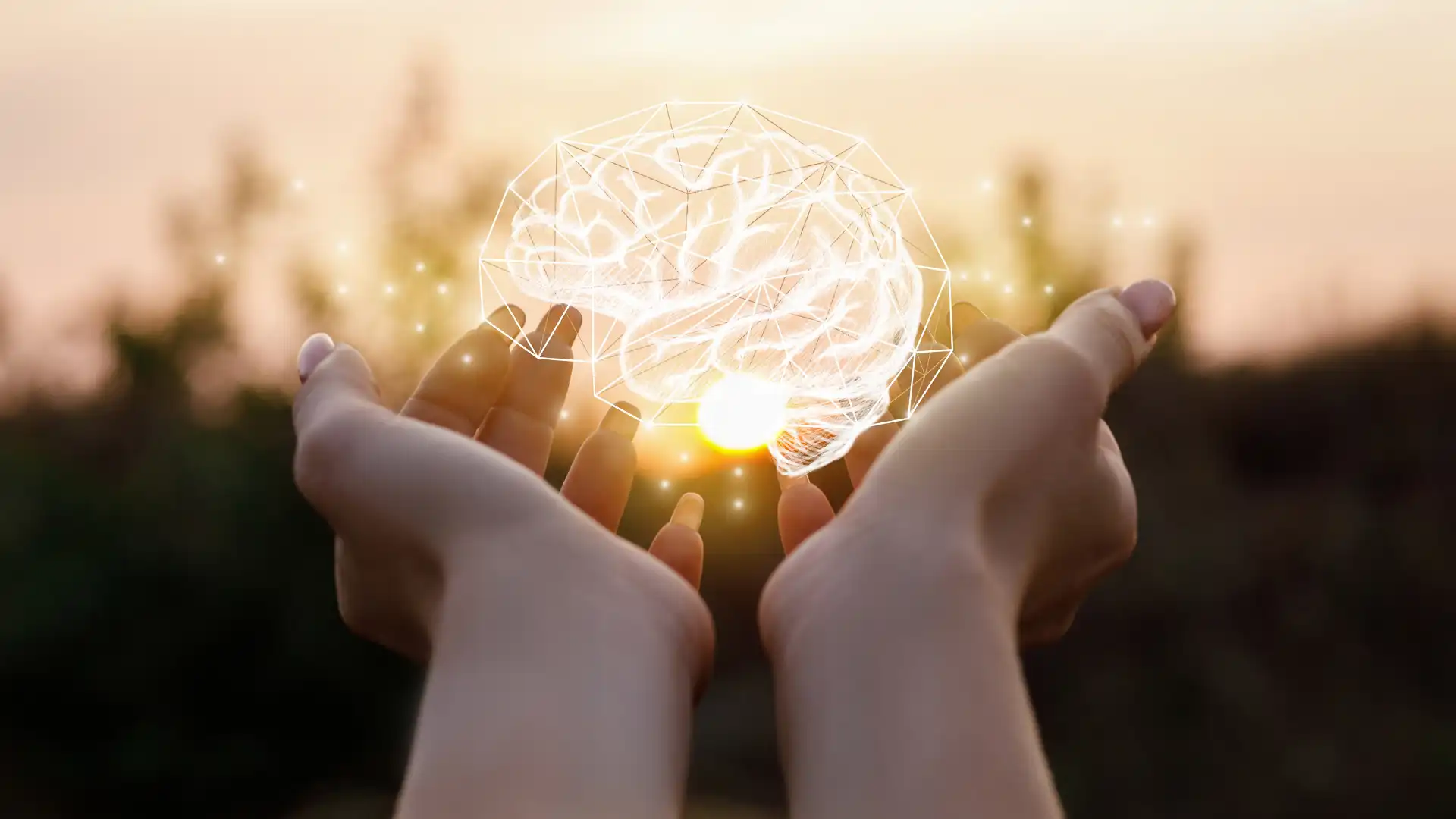 Two hands holding an illustration of a brain illuminated.