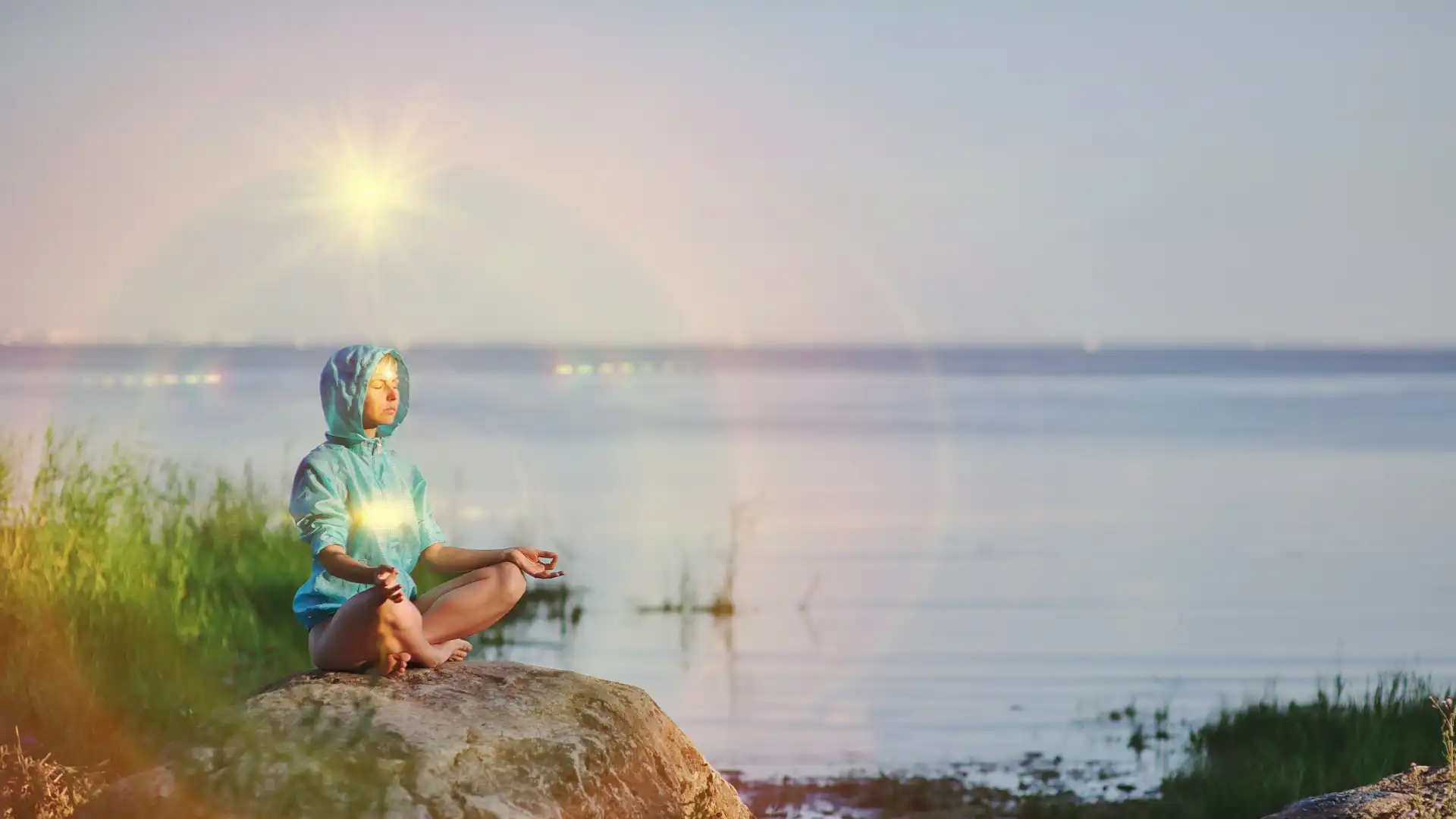 Woman seated in meditation practicing yoga with heart and crown chakra illuminated.