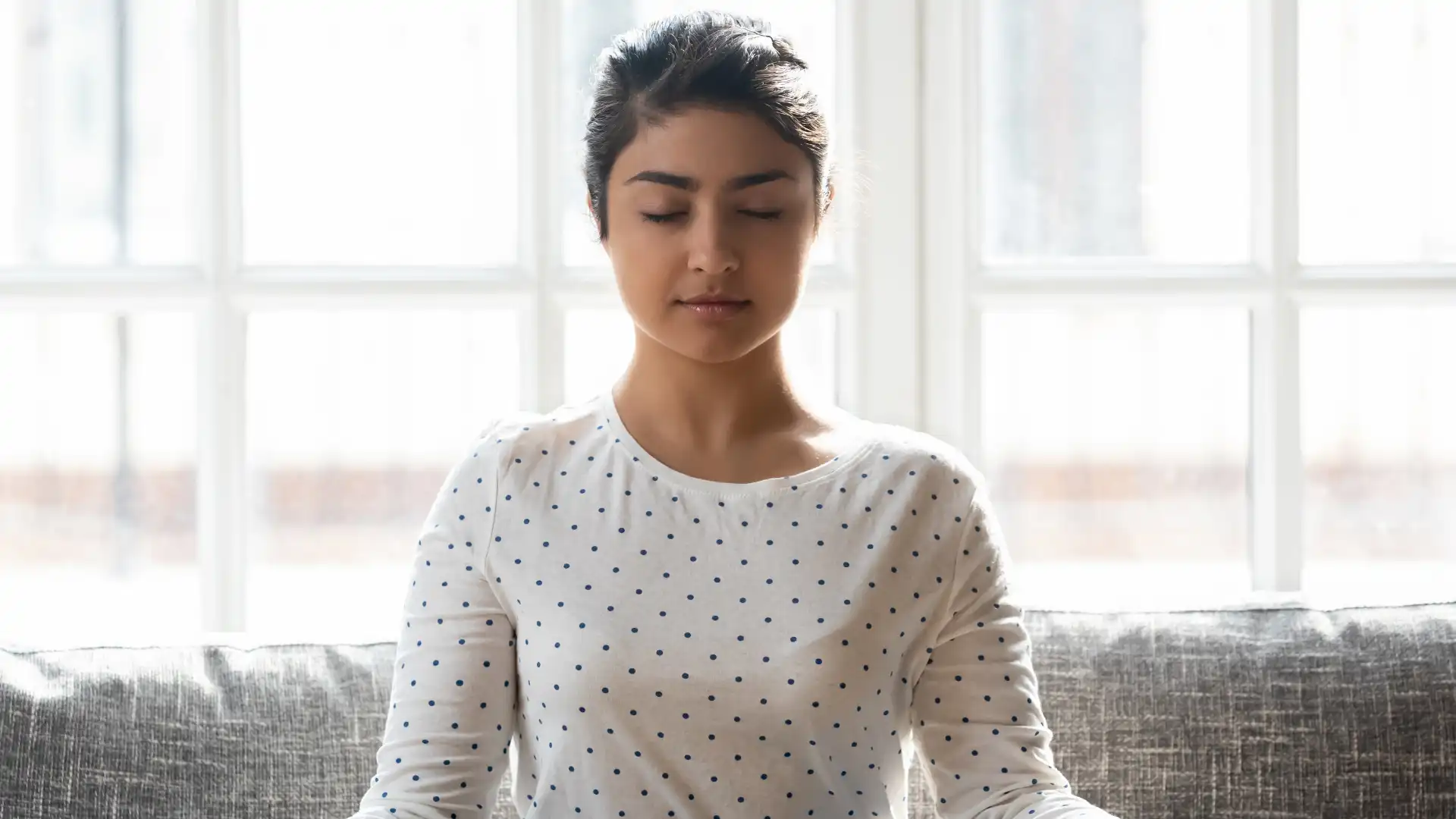 Woman practicing yoga meditation with eyes closed.