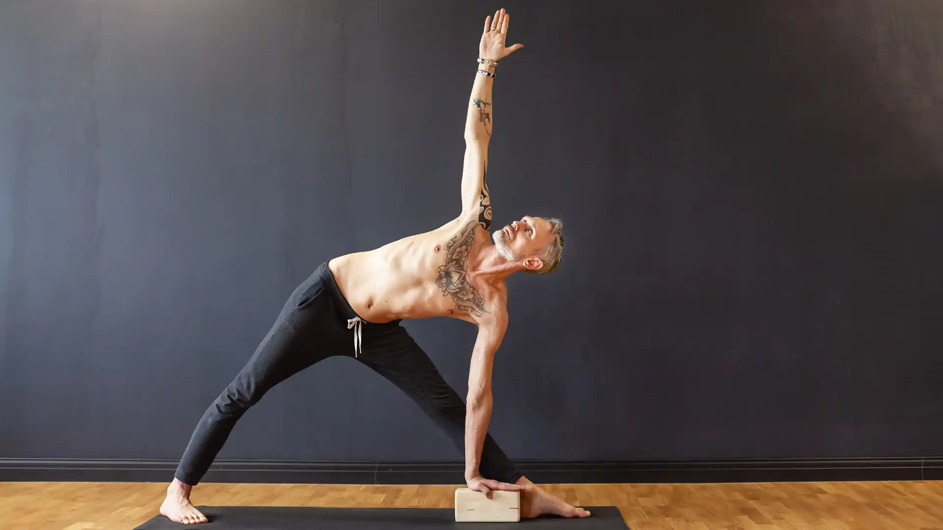 Man practicing yoga triangle pose.