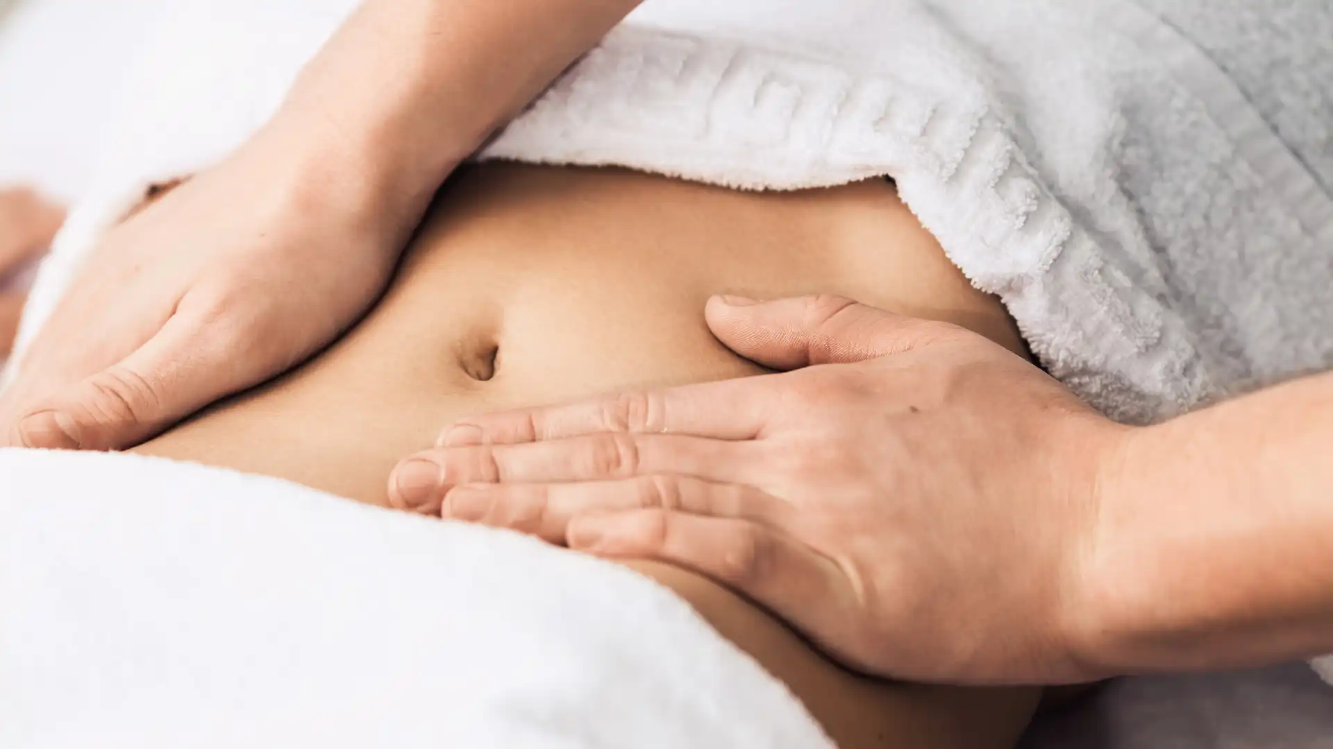 Closeup of woman receiving an abdominal massage.