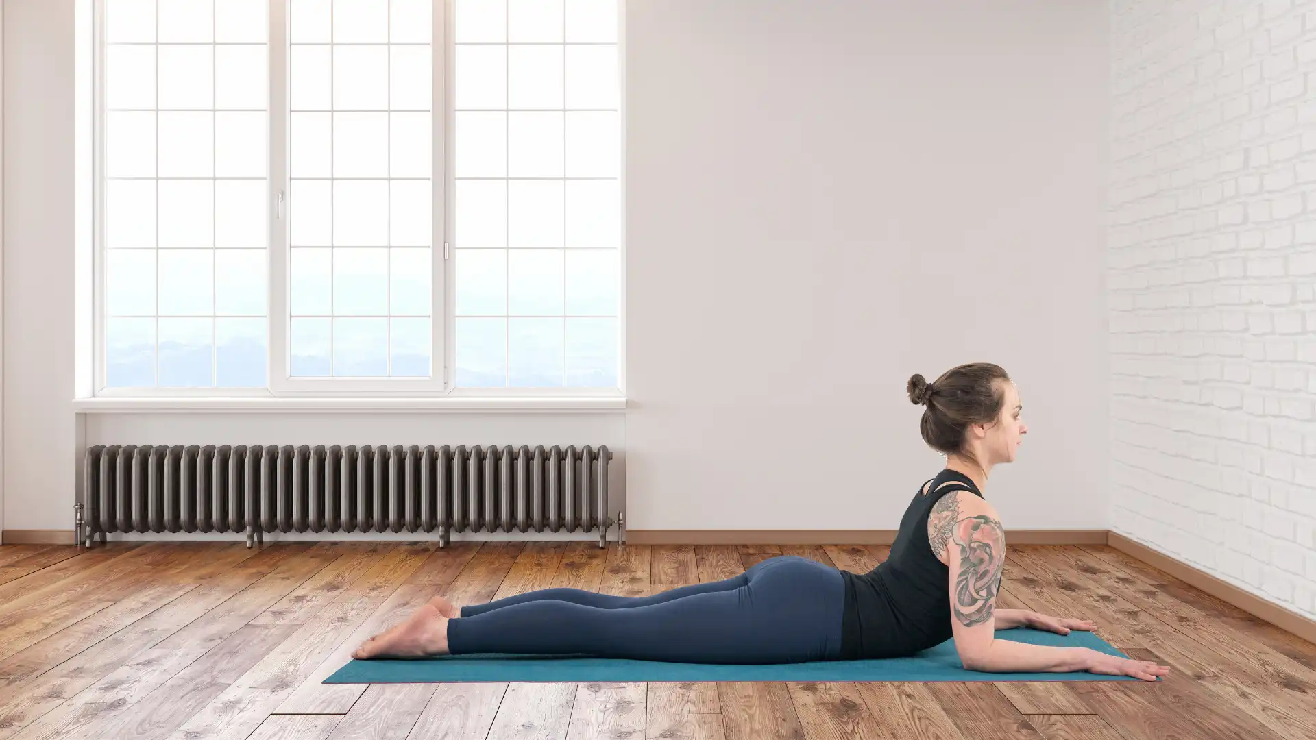 Woman practicing yoga sphinx pose.