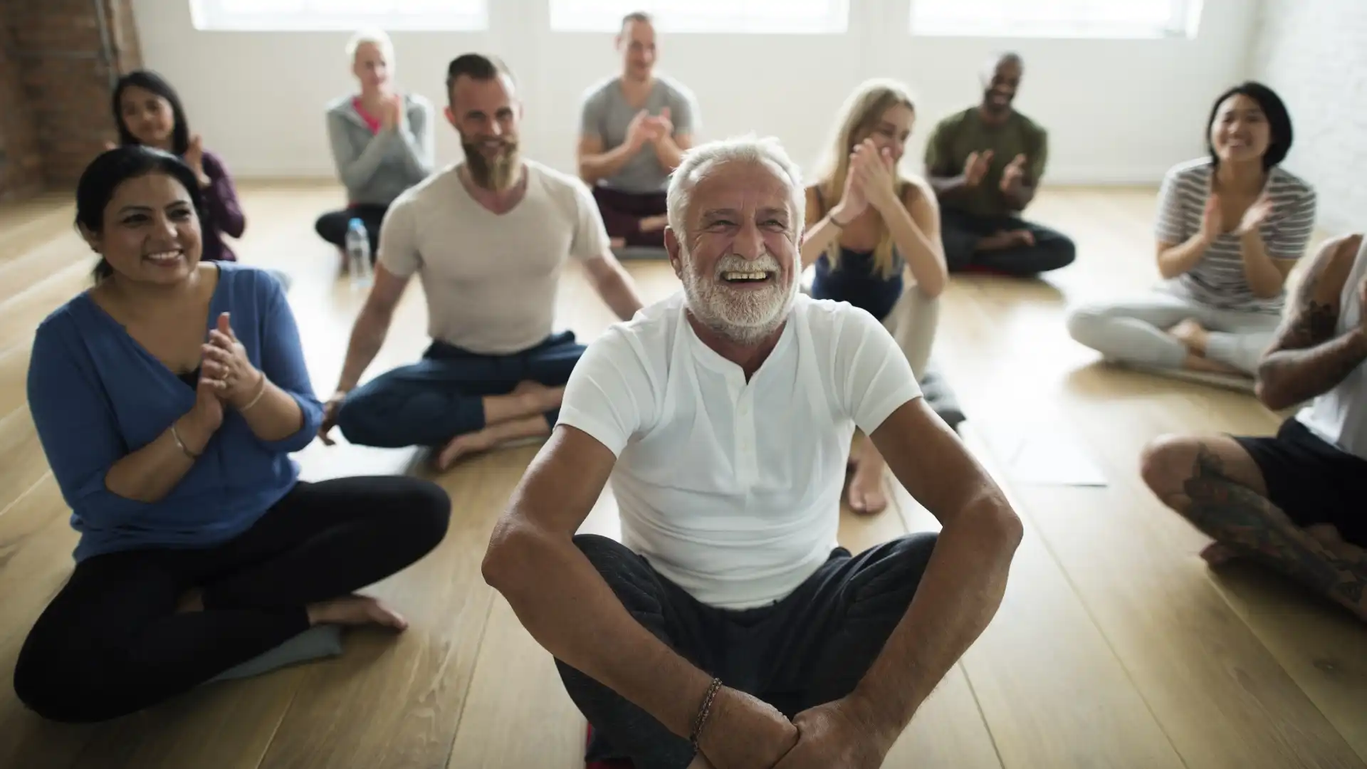 Group of yoga students lauging and relaxing after yoga class; laughter is a great way to boost immunity.