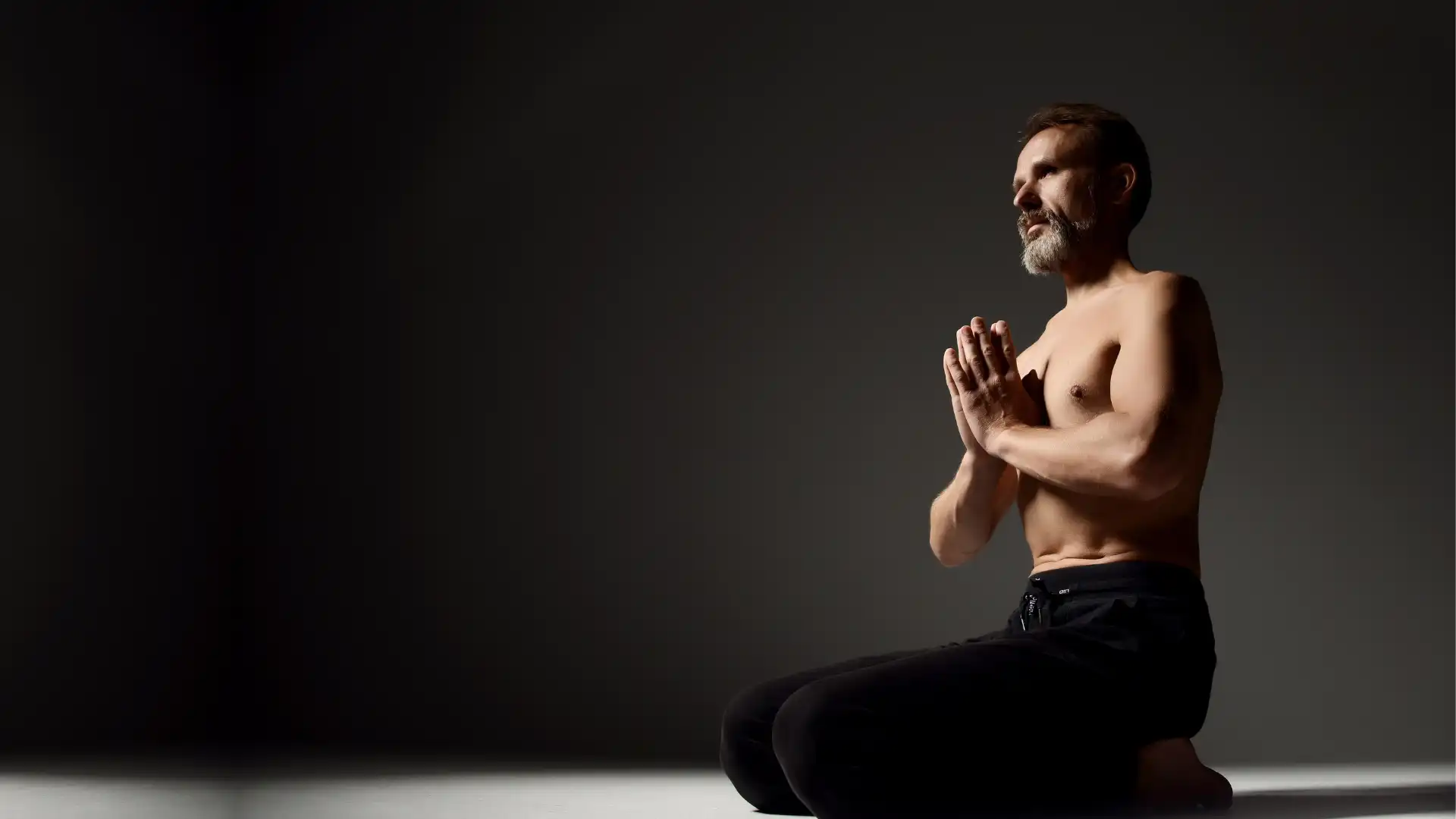 Male yoga student practicing meditation and yogic breathing pranayama.