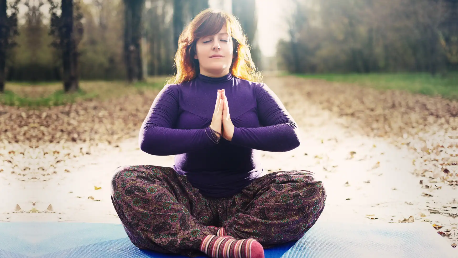 Woman practicing yoga meditation outside.