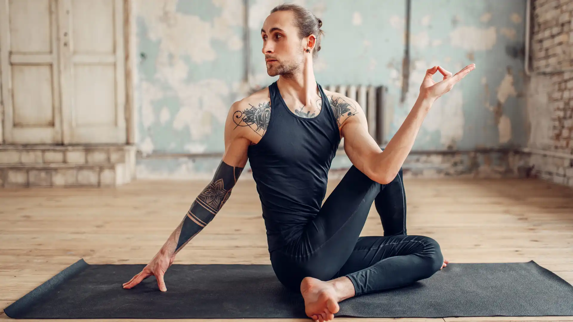 Male yoga student practicing yoga seated twist pose marichyasana to build a strong home yoga practice