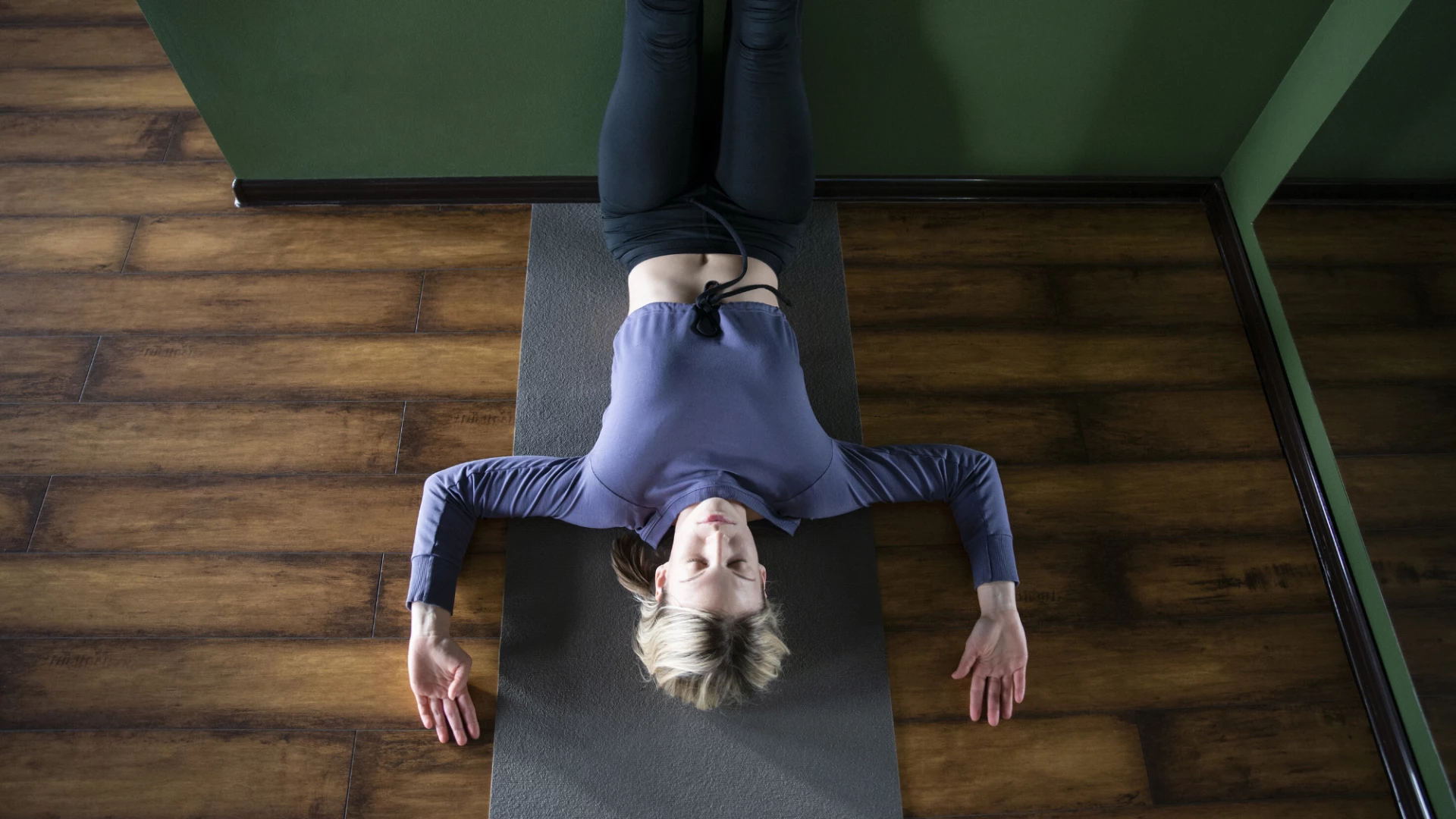 Woman practicing yoga - supported legs up the wall viparita karani.