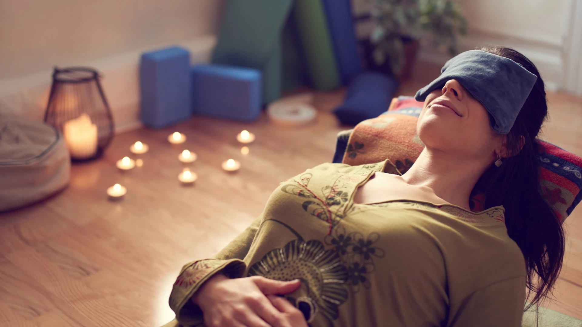 Woman practicing restorative yoga supta baddha konasana.