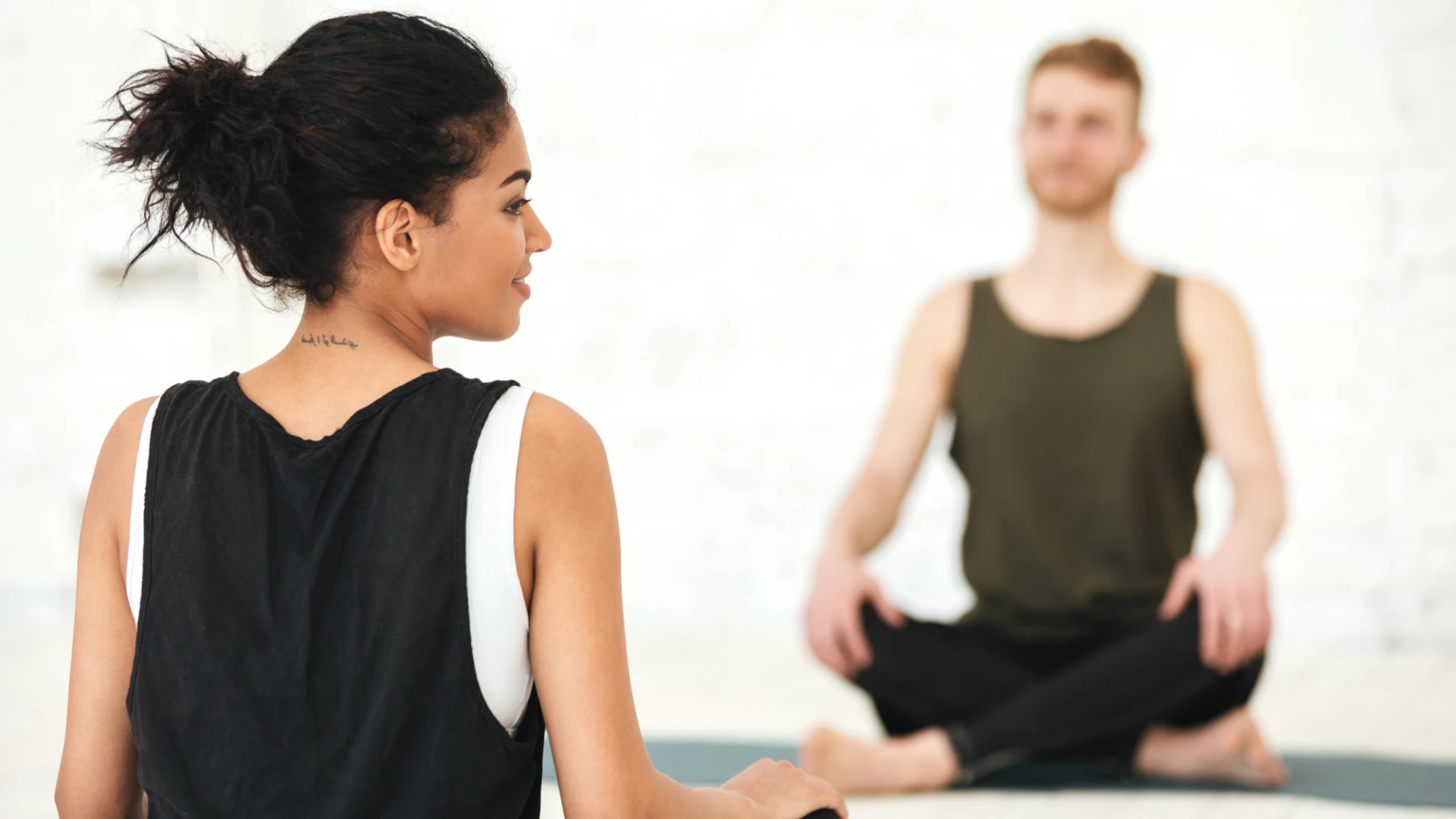 Female yoga teacher guiding her yoga student in mindful practice.