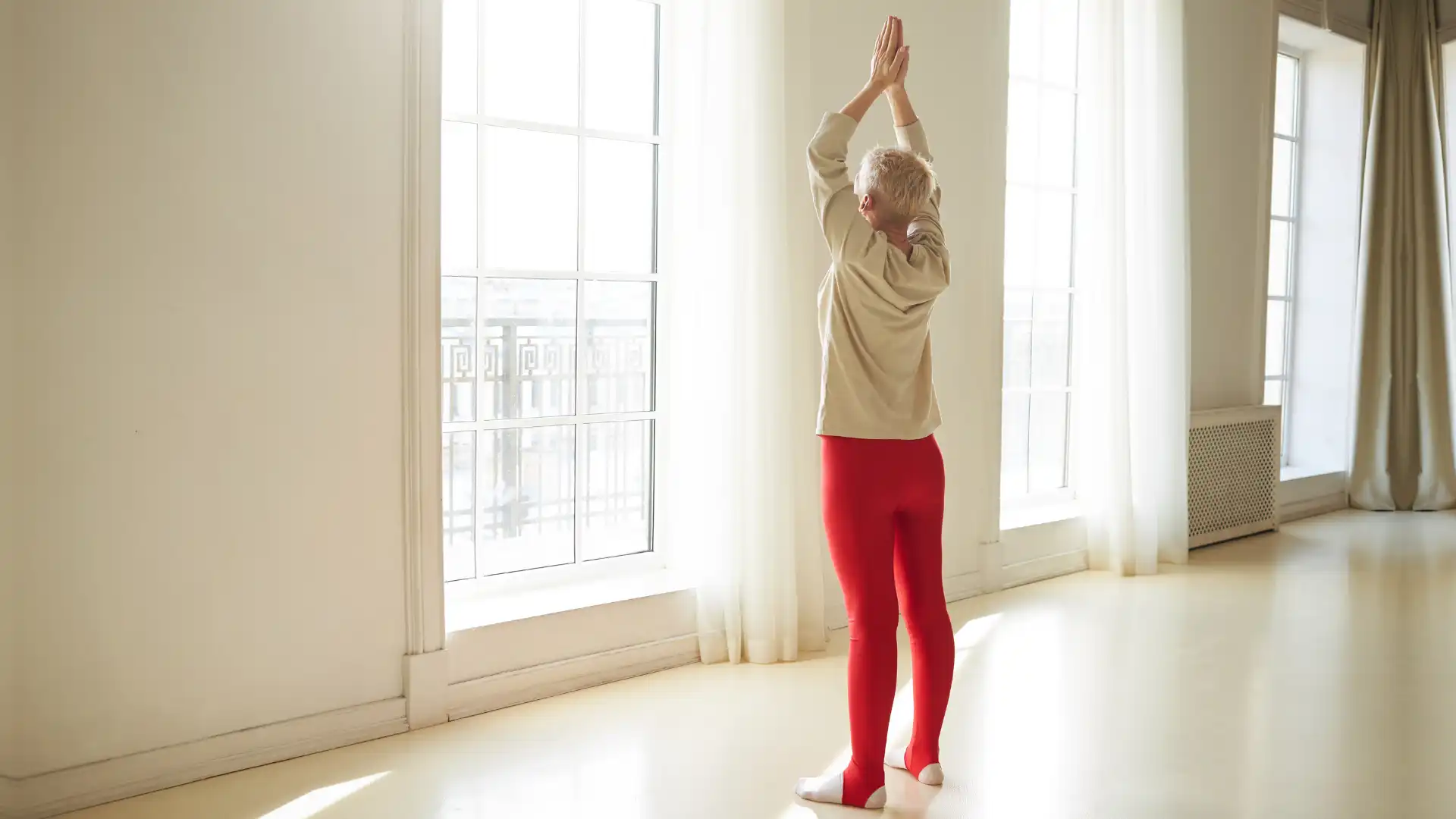 Woman practicing yoga urdhva hastasana.