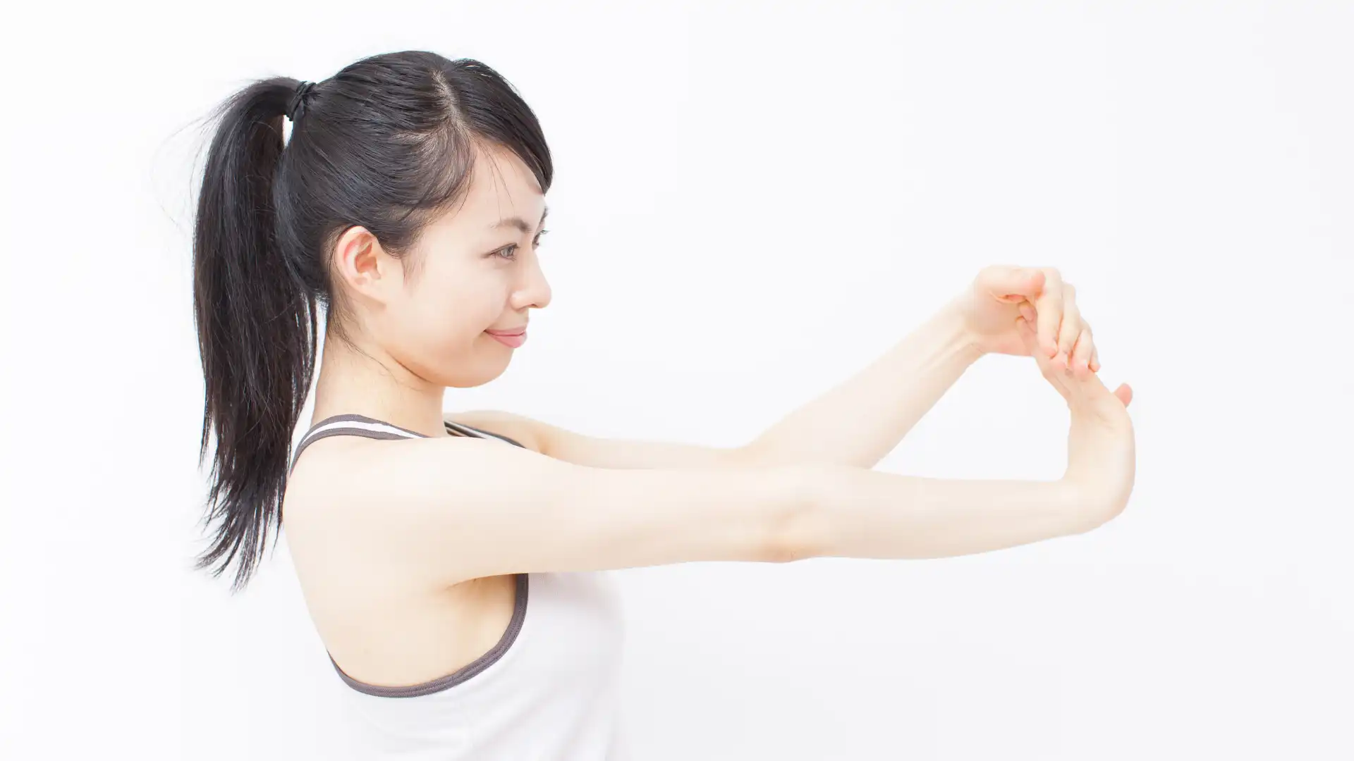 Woman practicing yoga wrist stretch.