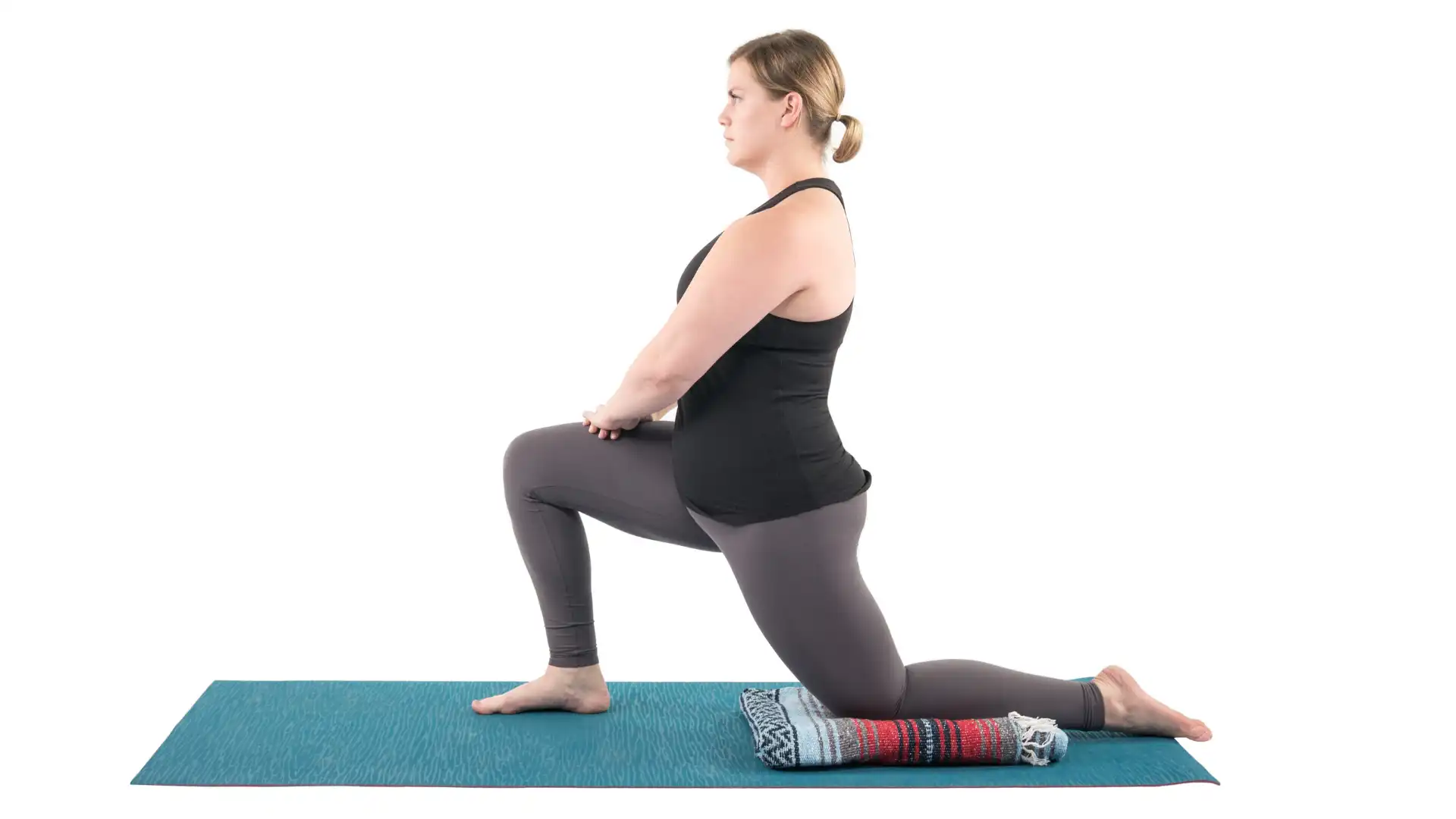 Woman practicing anjaneyasana yoga lunge pose.