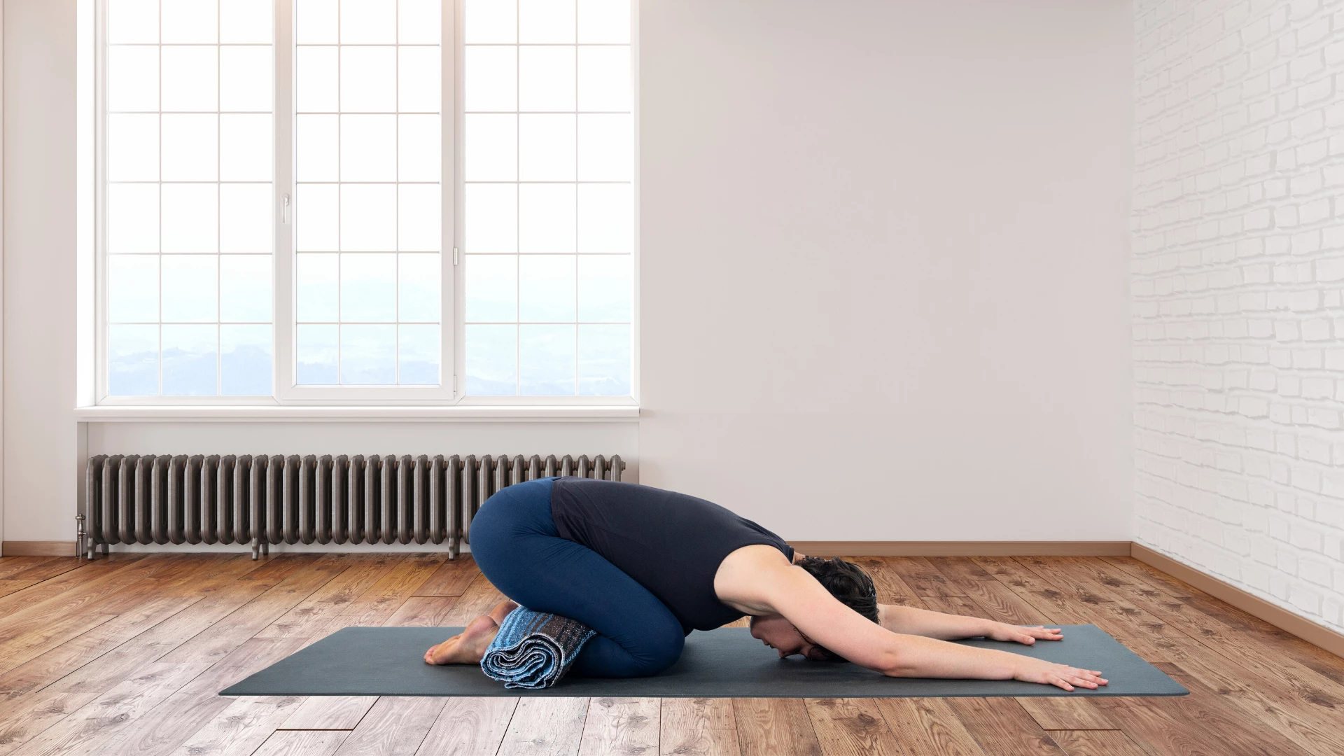 Woman practicing yoga child's pose.