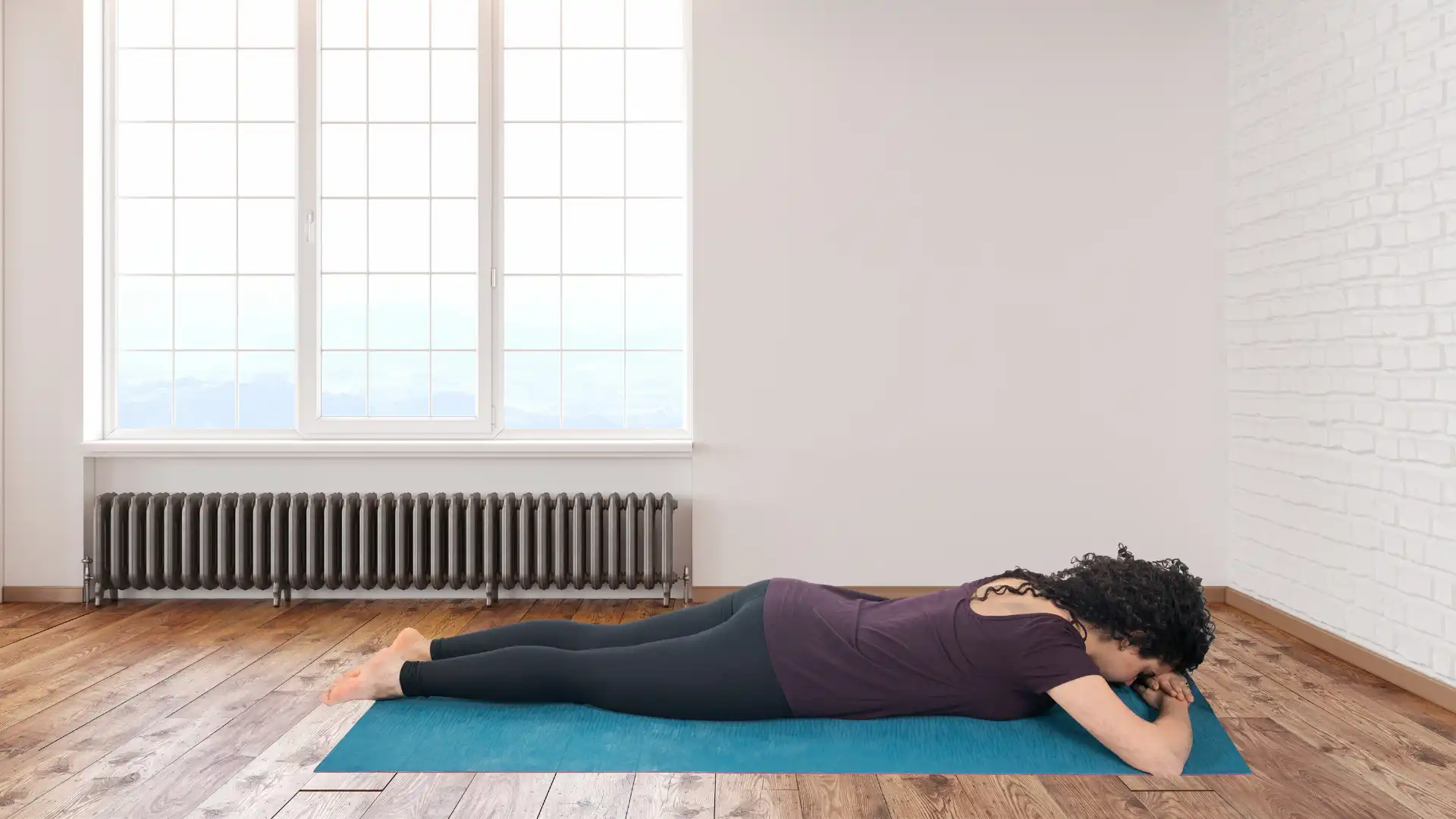 Woman practicing yoga crocodile pose.