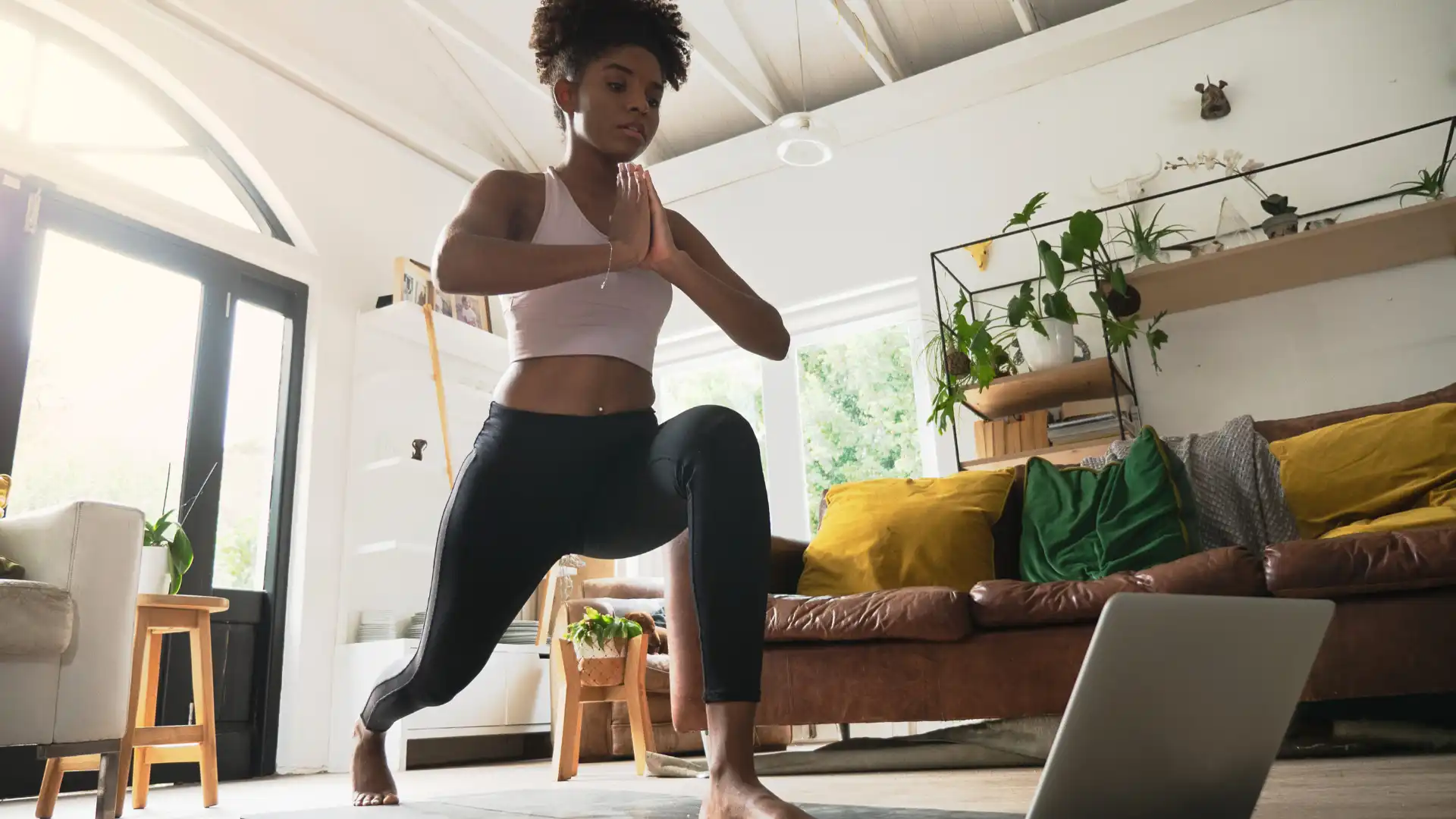 beginner yoga student practicing high lunge pose in online yoga class (sanskrit name anjaneyasana)